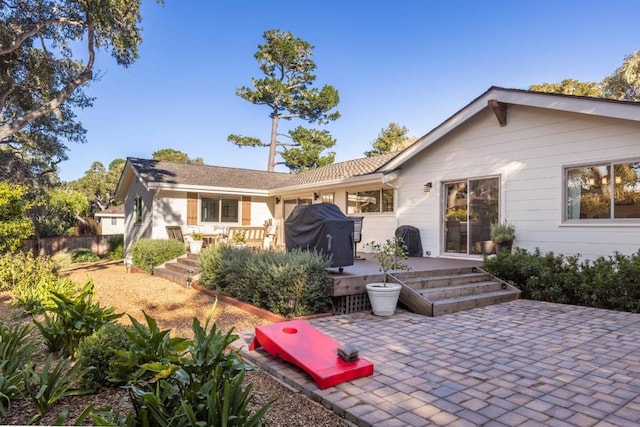 back of house featuring a deck and a patio area