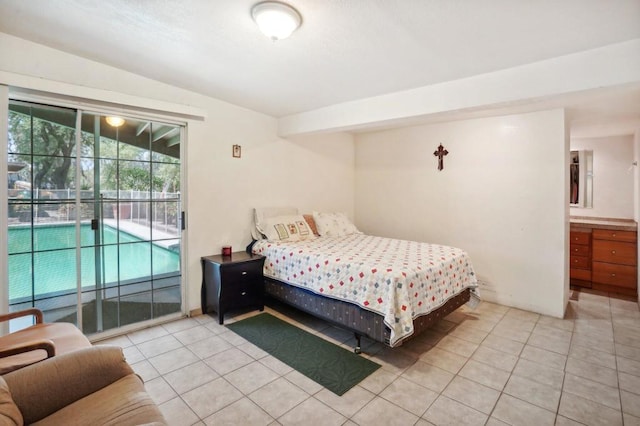 bedroom featuring ensuite bathroom, light tile patterned floors, lofted ceiling, and access to outside