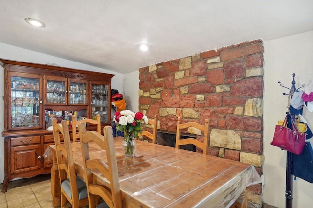 dining space featuring lofted ceiling and light tile patterned floors