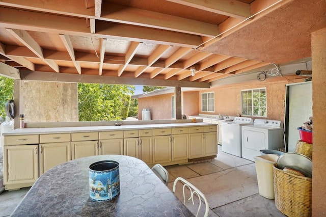 view of patio with exterior kitchen, an outdoor wet bar, and independent washer and dryer