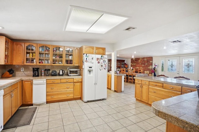 kitchen with sink, light tile patterned floors, decorative backsplash, and white appliances