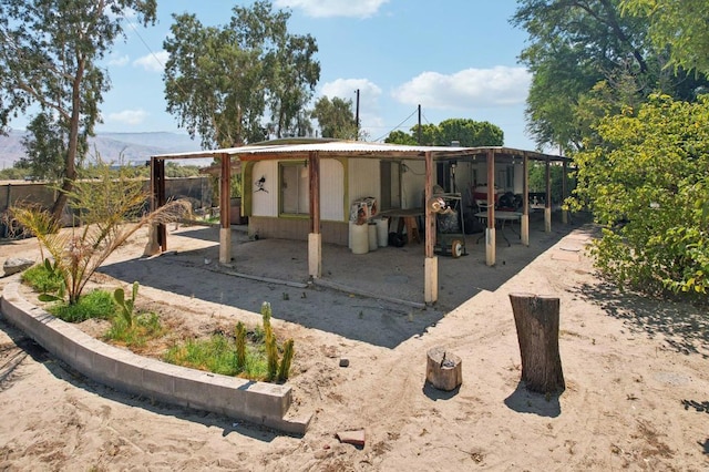 rear view of house with a mountain view and an outdoor structure