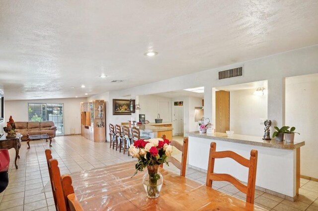 dining area featuring a textured ceiling and light tile patterned flooring