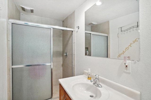 bathroom with an enclosed shower and vanity