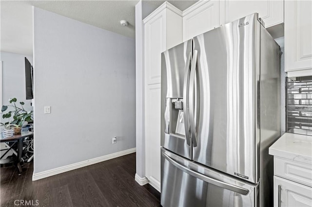 kitchen featuring stainless steel refrigerator with ice dispenser, white cabinetry, dark hardwood / wood-style floors, and decorative backsplash