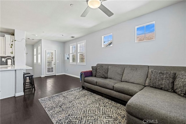 living room featuring ceiling fan, dark hardwood / wood-style floors, and sink