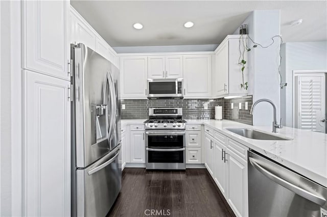 kitchen with stainless steel appliances, tasteful backsplash, dark hardwood / wood-style flooring, white cabinets, and sink