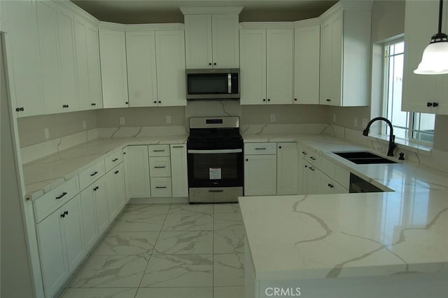 kitchen featuring appliances with stainless steel finishes, white cabinetry, sink, hanging light fixtures, and light stone counters