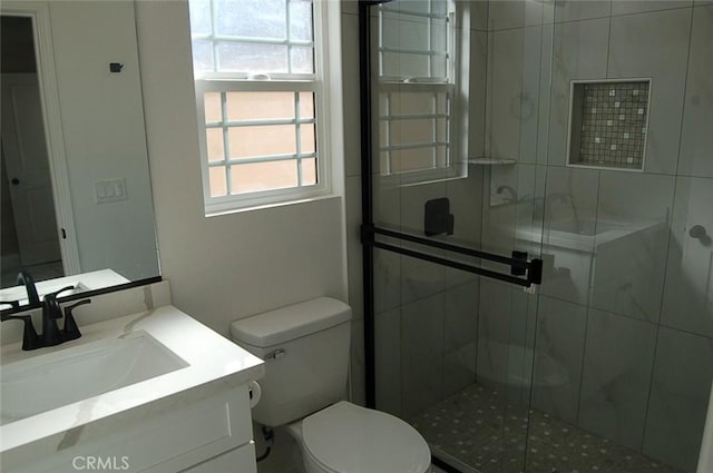 bathroom with walk in shower, vanity, and toilet