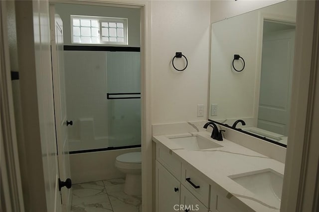 full bathroom featuring enclosed tub / shower combo, vanity, and toilet