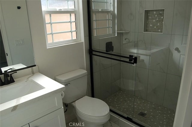 bathroom with walk in shower, vanity, and toilet