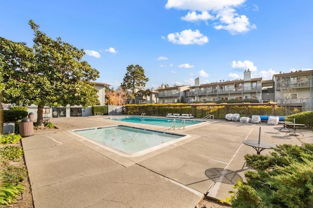 view of pool featuring a hot tub and a patio area