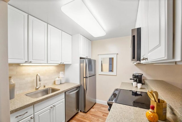 kitchen featuring white cabinetry, sink, decorative backsplash, and stainless steel appliances