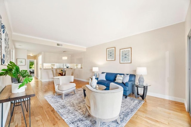 living room featuring crown molding and light hardwood / wood-style floors