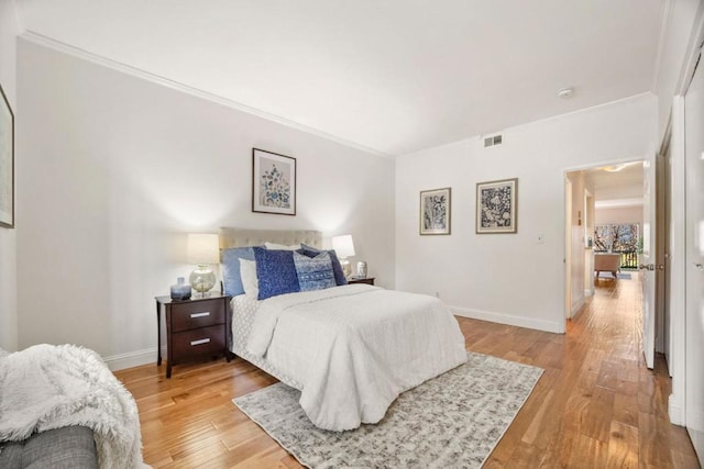 bedroom featuring crown molding and light hardwood / wood-style floors