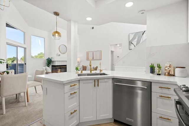 kitchen featuring light carpet, appliances with stainless steel finishes, decorative light fixtures, white cabinets, and sink