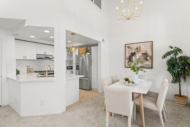 dining area featuring a high ceiling and an inviting chandelier