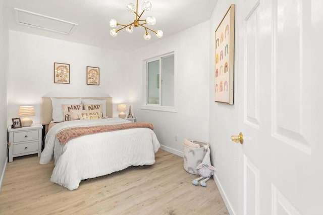 bedroom featuring an inviting chandelier and light hardwood / wood-style floors