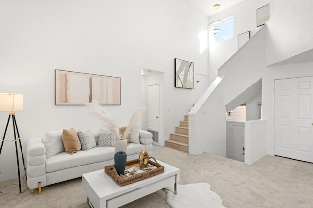 living room featuring light carpet and a towering ceiling