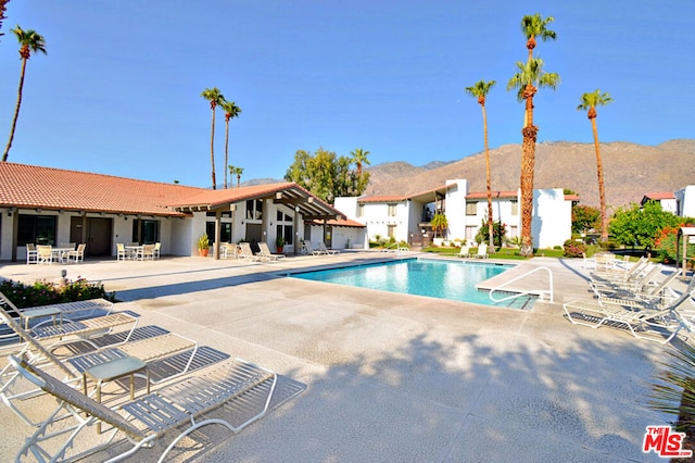 view of pool featuring a mountain view and a patio