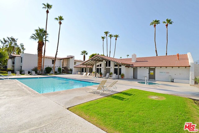 view of swimming pool featuring a yard and a patio