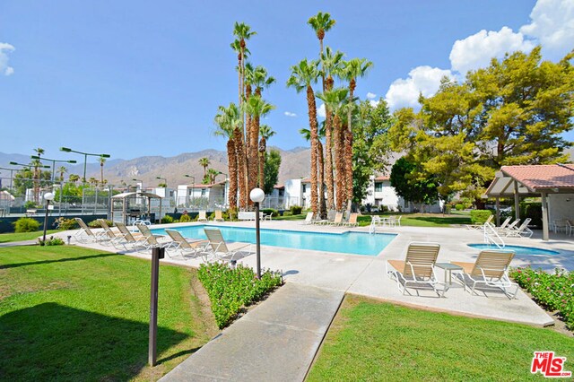 view of pool featuring a yard, a mountain view, and a patio