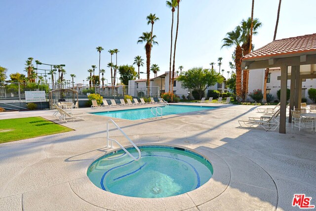 view of pool featuring a hot tub and a patio