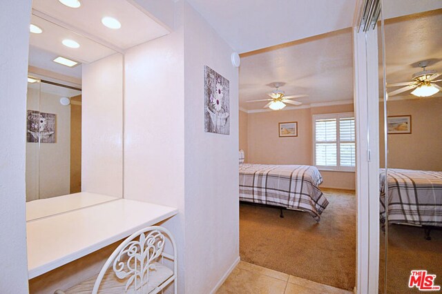 carpeted bedroom with ceiling fan and ornamental molding