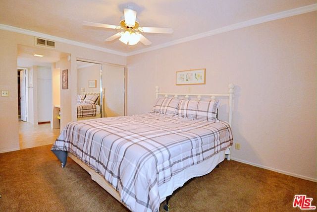 bedroom with ceiling fan, a closet, crown molding, and carpet flooring