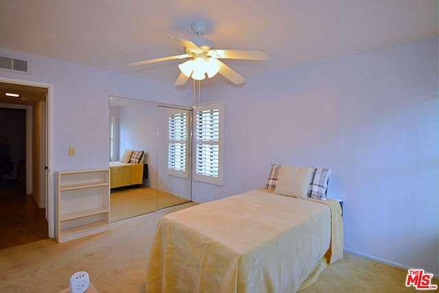 carpeted bedroom with ceiling fan and a closet