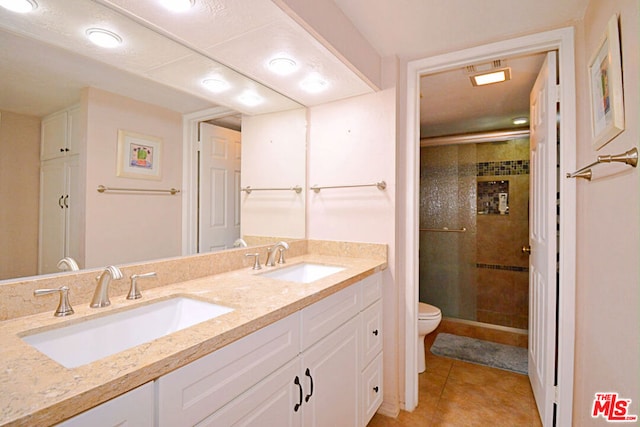 bathroom with toilet, vanity, an enclosed shower, and tile patterned flooring