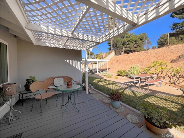 deck featuring a lawn and a pergola