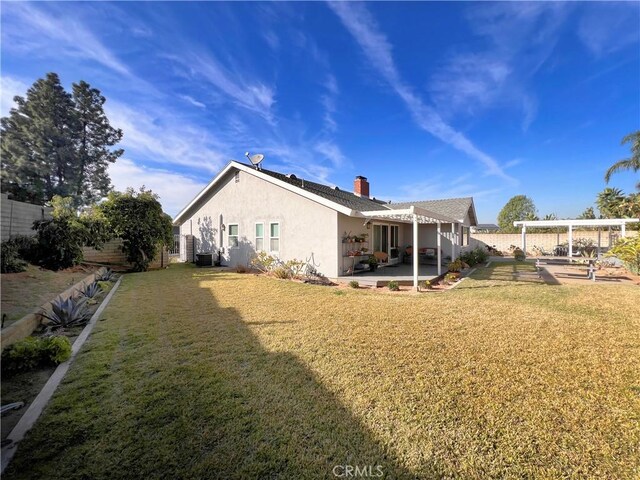 back of property featuring central air condition unit, a pergola, a patio area, and a yard