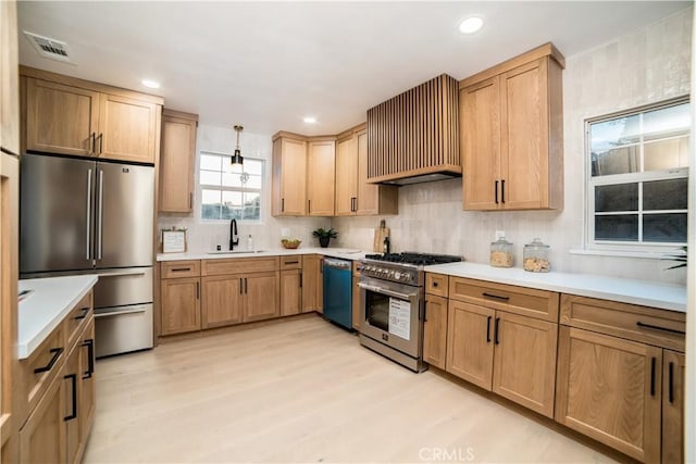 kitchen with appliances with stainless steel finishes, custom exhaust hood, sink, backsplash, and light wood-type flooring