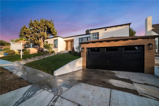 view of front of home with a garage and a yard