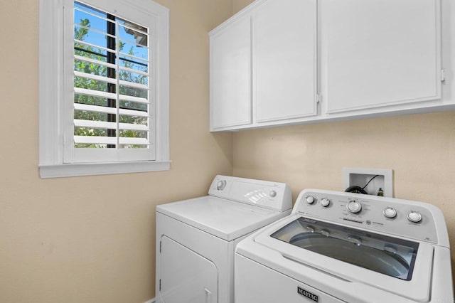 washroom featuring cabinets and separate washer and dryer