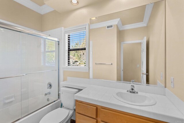 full bathroom featuring toilet, bath / shower combo with glass door, vanity, and ornamental molding