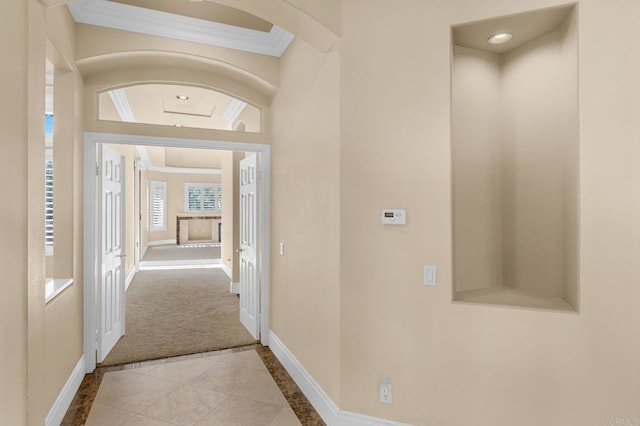 corridor featuring crown molding and light colored carpet