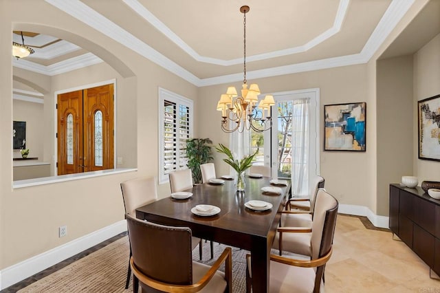 dining room with an inviting chandelier, crown molding, and a tray ceiling