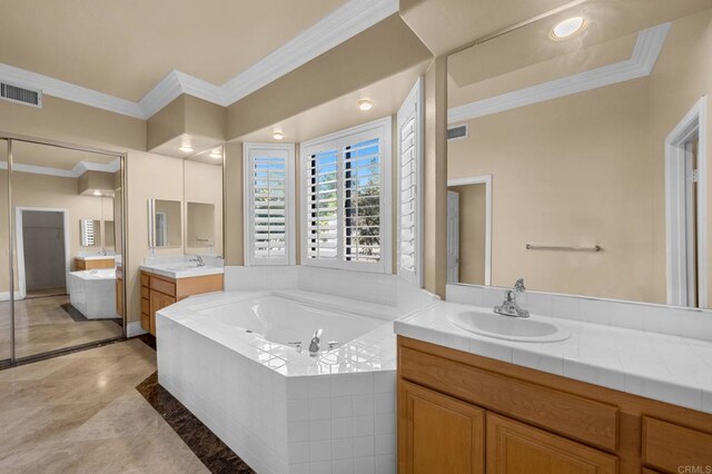 bathroom with crown molding, a relaxing tiled tub, and vanity