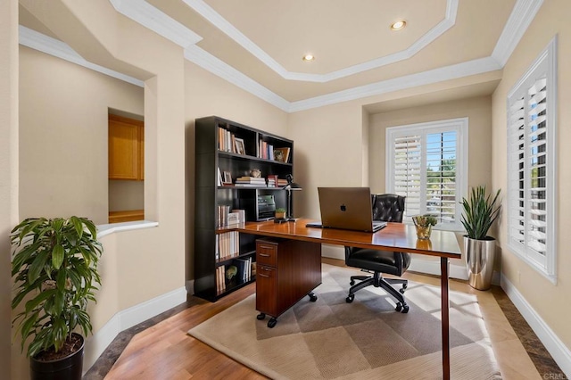 office space with light hardwood / wood-style floors, a raised ceiling, and crown molding