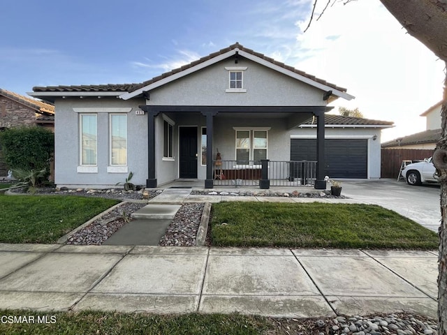 view of front facade featuring a garage, covered porch, and a front lawn