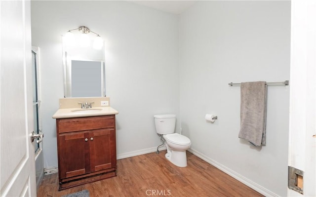 bathroom with toilet, vanity, and hardwood / wood-style flooring