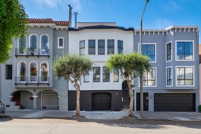 view of front of property featuring a balcony and a garage