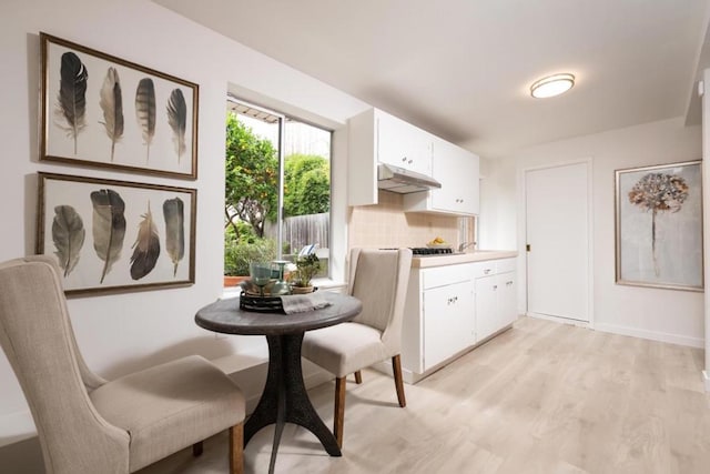 kitchen featuring white cabinets, light hardwood / wood-style floors, and decorative backsplash