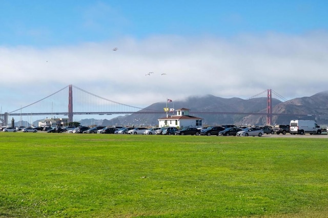 view of home's community with a mountain view and a lawn