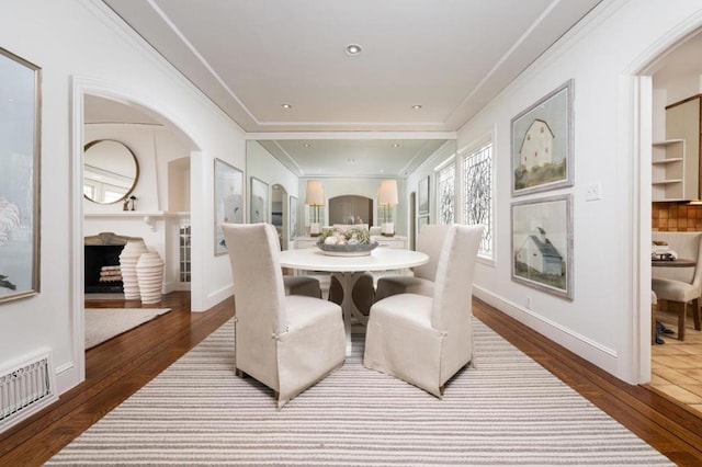 dining space with hardwood / wood-style flooring and crown molding