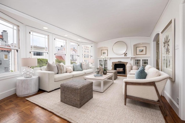 living room featuring lofted ceiling, parquet floors, and a stone fireplace