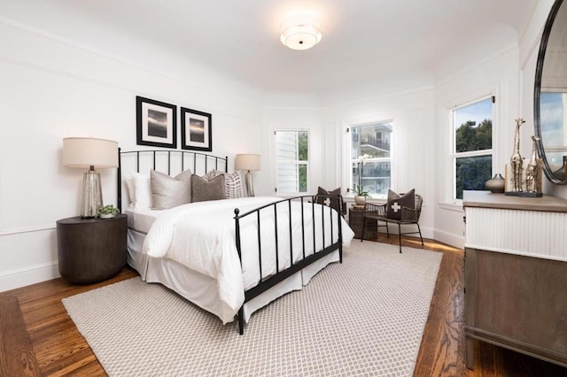 bedroom with dark hardwood / wood-style flooring and multiple windows