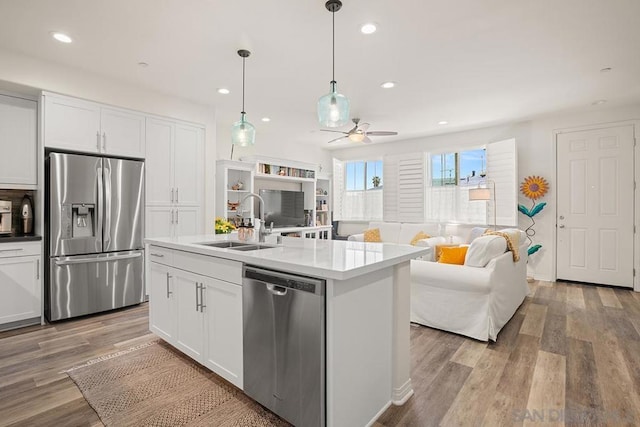 kitchen with white cabinets, a kitchen island with sink, and stainless steel appliances